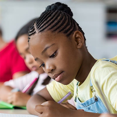 Elementary aged girl studying with classmates