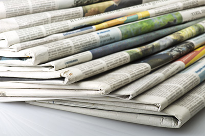 Stack of print newspapers, neatly folded