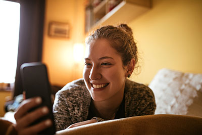 Teen texting and smiling