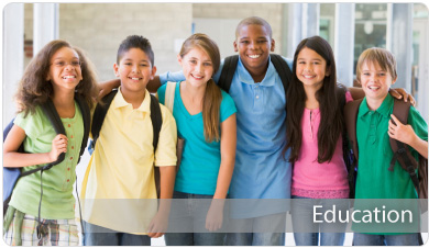 Photo of diverse group of pre-teens in multicolored shirts, smiling at the camera.