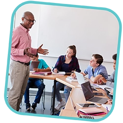 This is a photo in a light teal frame. In the photo is an adult teaching a group of young people in a classroom setting.