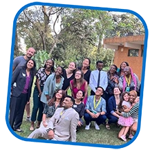 This is an image of a group of people posing and smiling for a picture. The people are gathered outdoors at a conference.